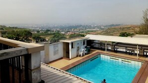 A rooftop pool with a view of a cityscape. - Grangehill Hotel and Resort  (Abuja)