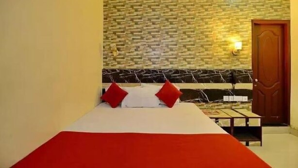 Una habitación con cama, una puerta de madera y una pared con diseño de ladrillo.