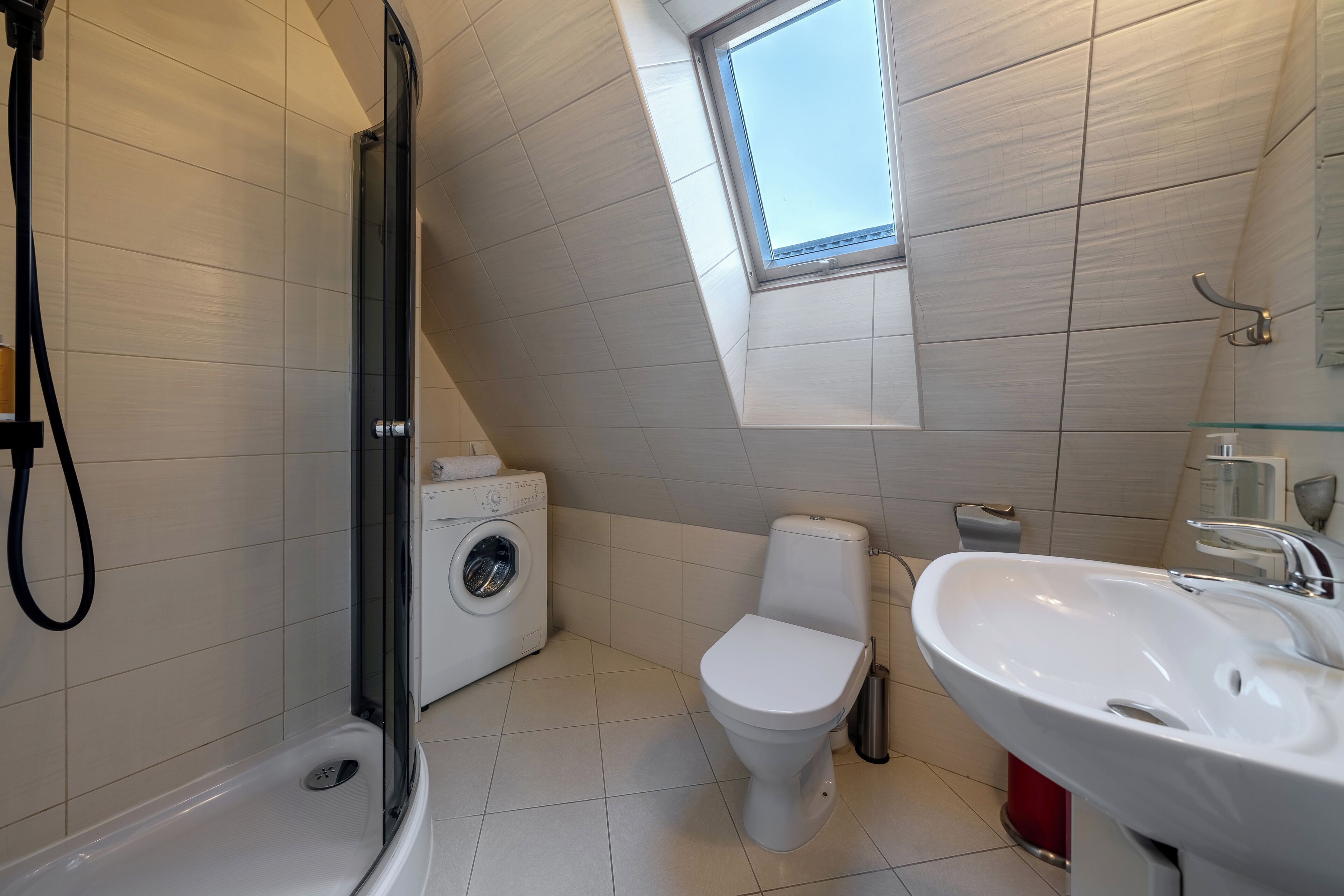 A modern bathroom with a shower, toilet, and sink.