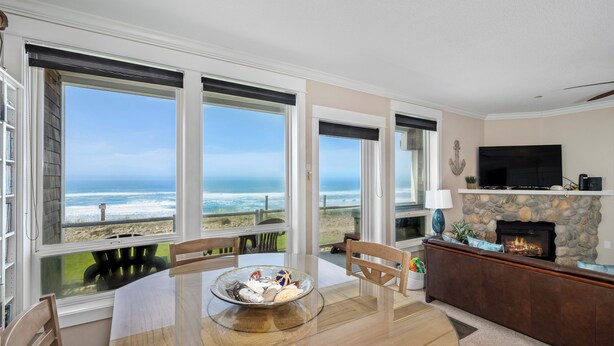 A spacious living room with a large table, a fireplace, and a television.