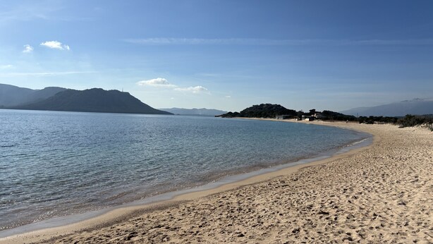 A beach with clear blue water, sandy shore, and distant mountains. - Apart  with heated pool by Pinarello Villa Services (Lecci)