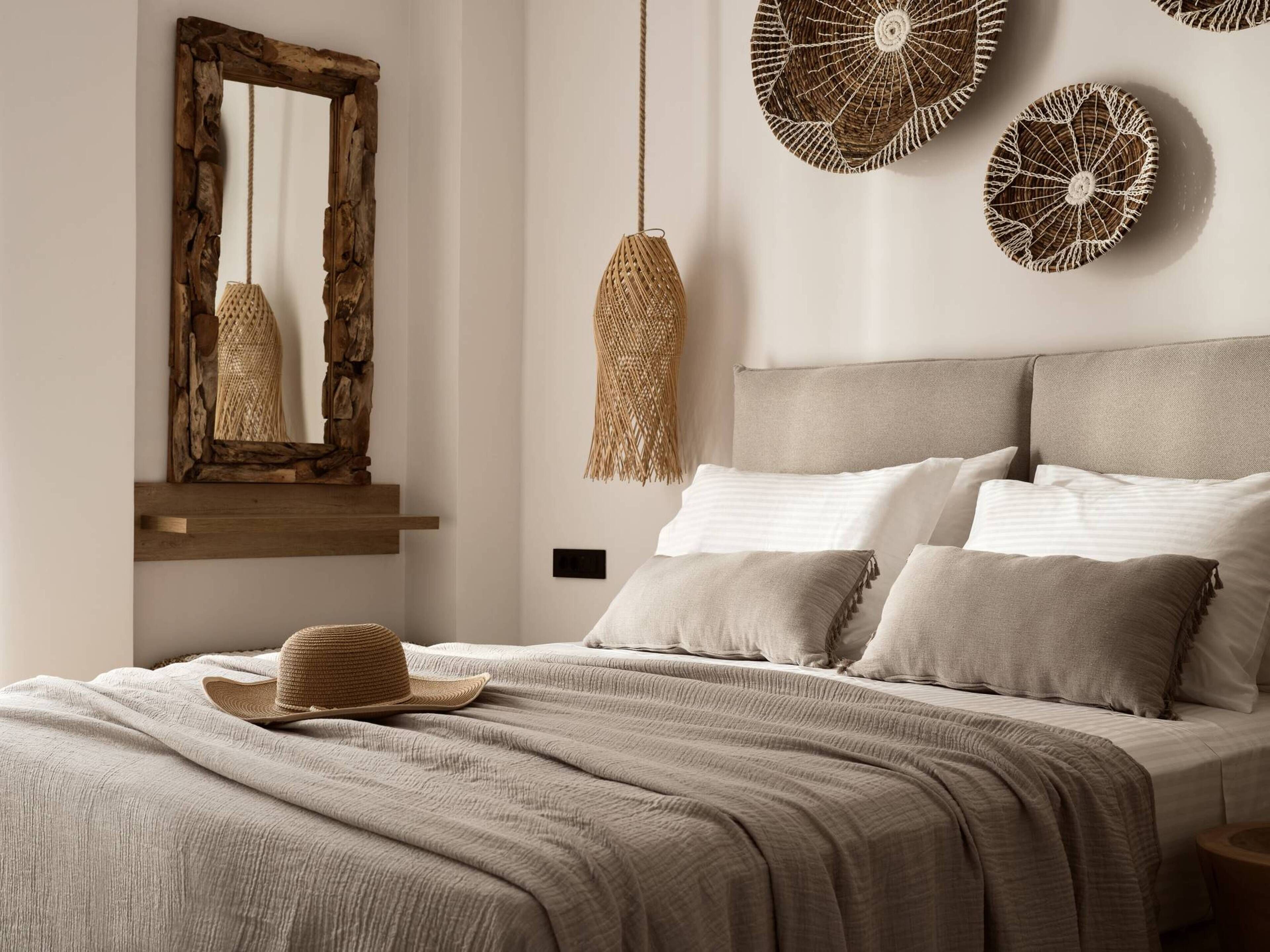 Un dormitorio con una cama, una lámpara colgante y un espejo instalado en la pared.