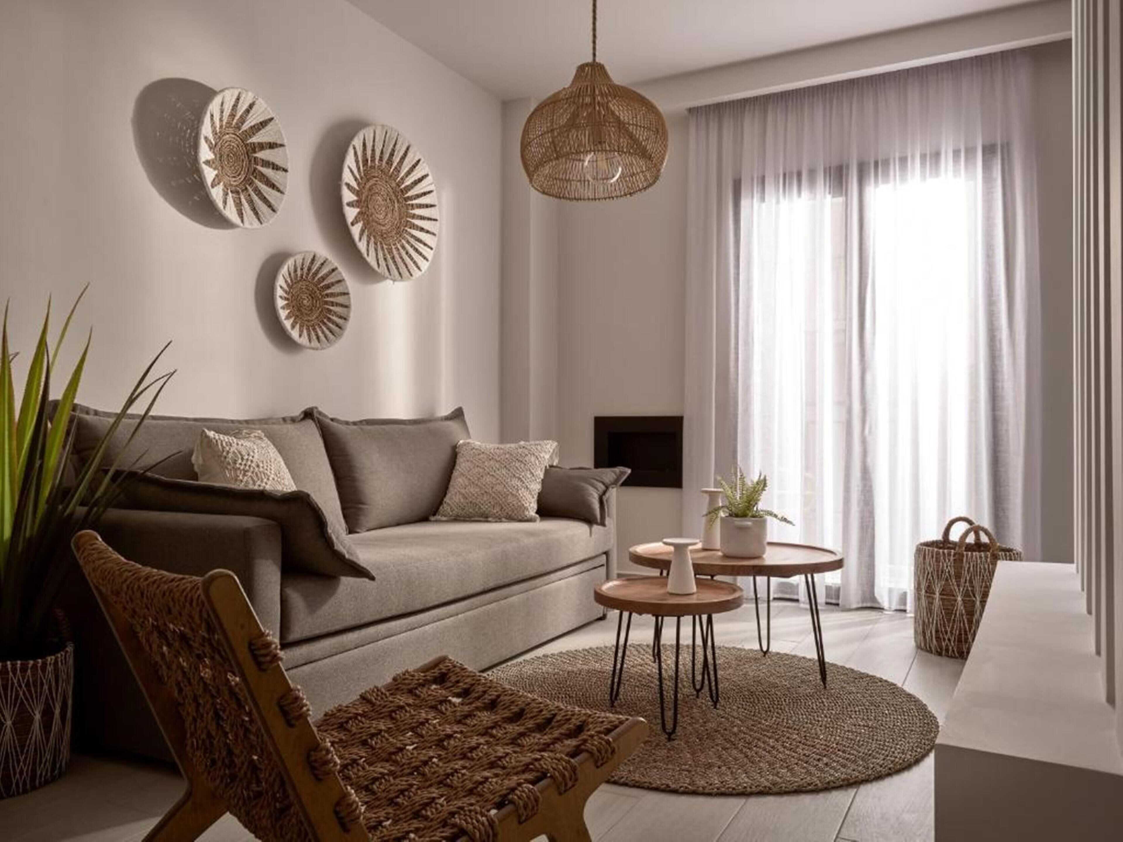 A modern living room with a sofa, a round coffee table, and a hanging light fixture.