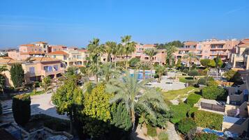 A residential area with multiple apartment buildings, a swimming pool, and well-maintained gardens.