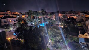 A nighttime view of a resort with multiple buildings, a swimming pool, and well-lit pathways. - Luxurious Penthouse with Spacious Terrace in Limnaria Gardens, Paphos (Paphos)