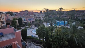A resort with multiple buildings, a swimming pool, and palm trees. - Luxurious Penthouse with Spacious Terrace in Limnaria Gardens, Paphos (Paphos)