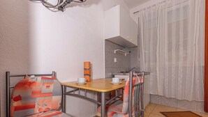 Una cocina funcional con una mesa y sillas de madera, una pequeña encimera y un lavamanos.