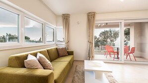 A modern living room with a sofa, a coffee table, and a dining area with chairs. - Sargas Suite 5 with pool view (Novalja)