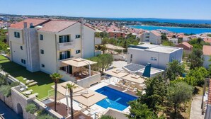 A modern multi-story building with a rooftop pool and a view of the sea. - Sargas Suite 6 with city view (Novalja)