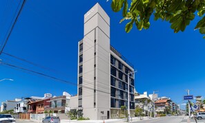 A modern building with a prominent vertical section and a sign reading "CAICO". - Studios in Building With Swimming Pool in Jurere - SOT (Florianópolis)