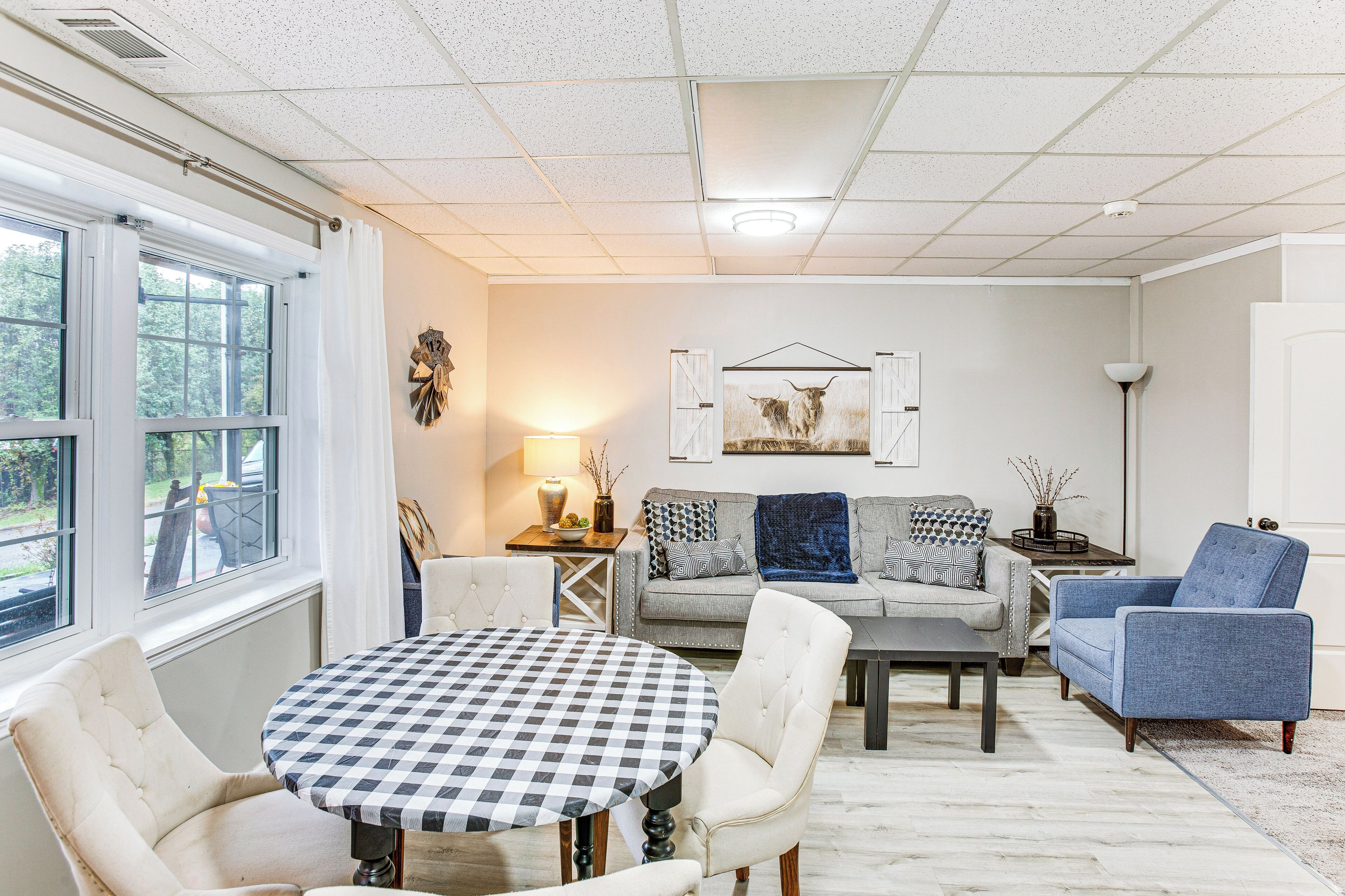 A living room with a checkered table, a sofa, a blue armchair, and a lamp.