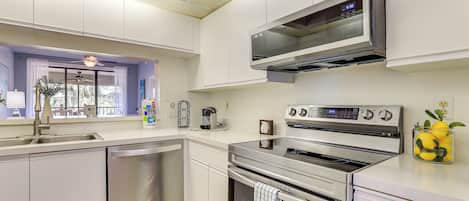 Una cocina moderna con electrodomésticos de acero inoxidable, horno empotrado y microondas.