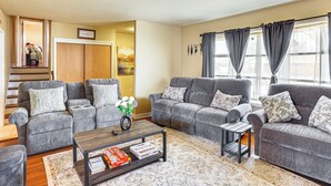 A living room with grey sofas, a coffee table, and a rug. There is a staircase leading to another room. - 3 Mi to Berkshire Mall: Suburban Stay w/ Yard! (Sinking Spring)