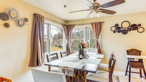 A dining area with a large table, chairs, a ceiling fan, and a view through the windows. - 3 Mi to Berkshire Mall: Suburban Stay w/ Yard! (Sinking Spring)