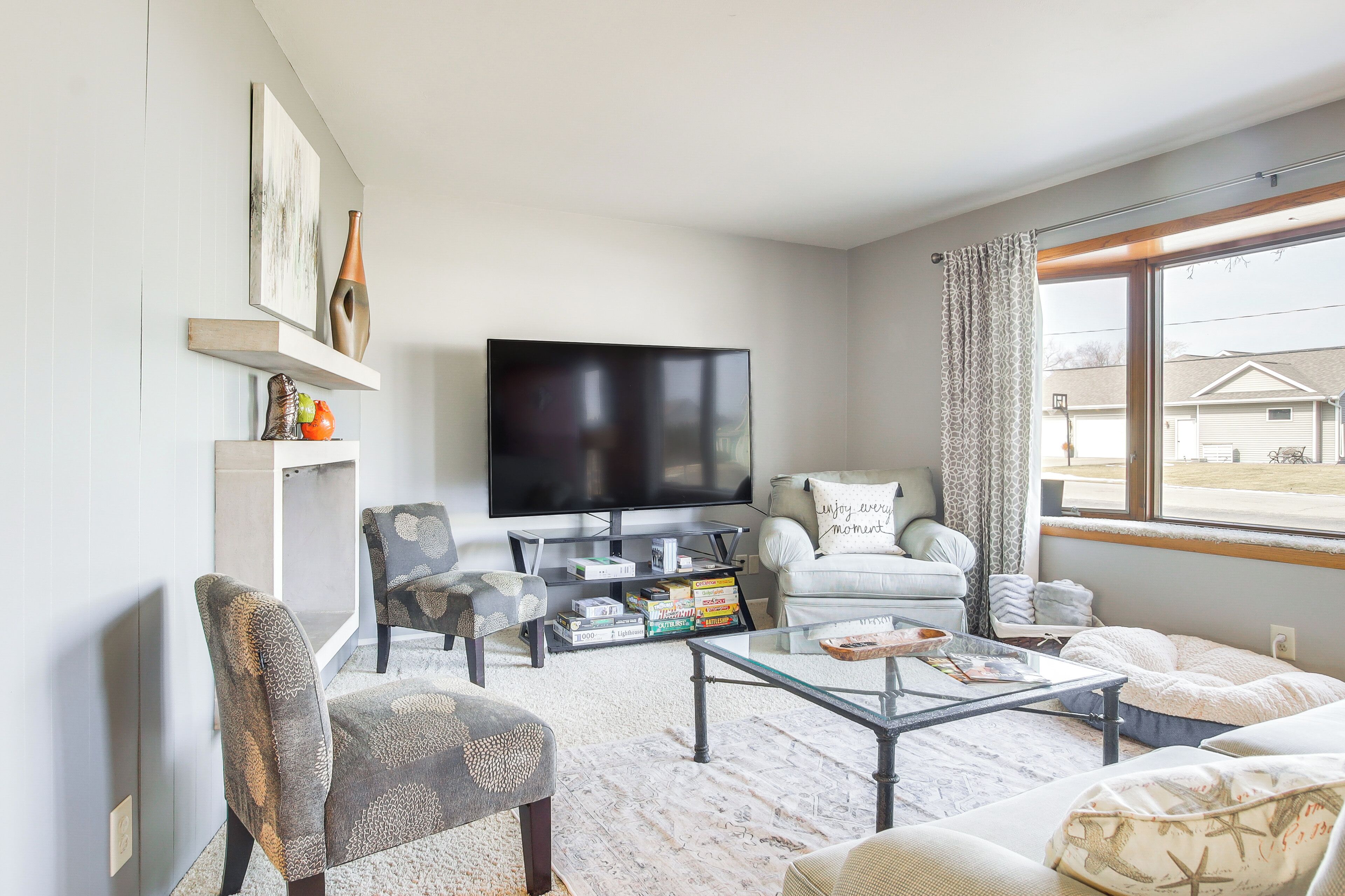 A living room with a flat-screen TV, a sofa, a coffee table, and a bookshelf.