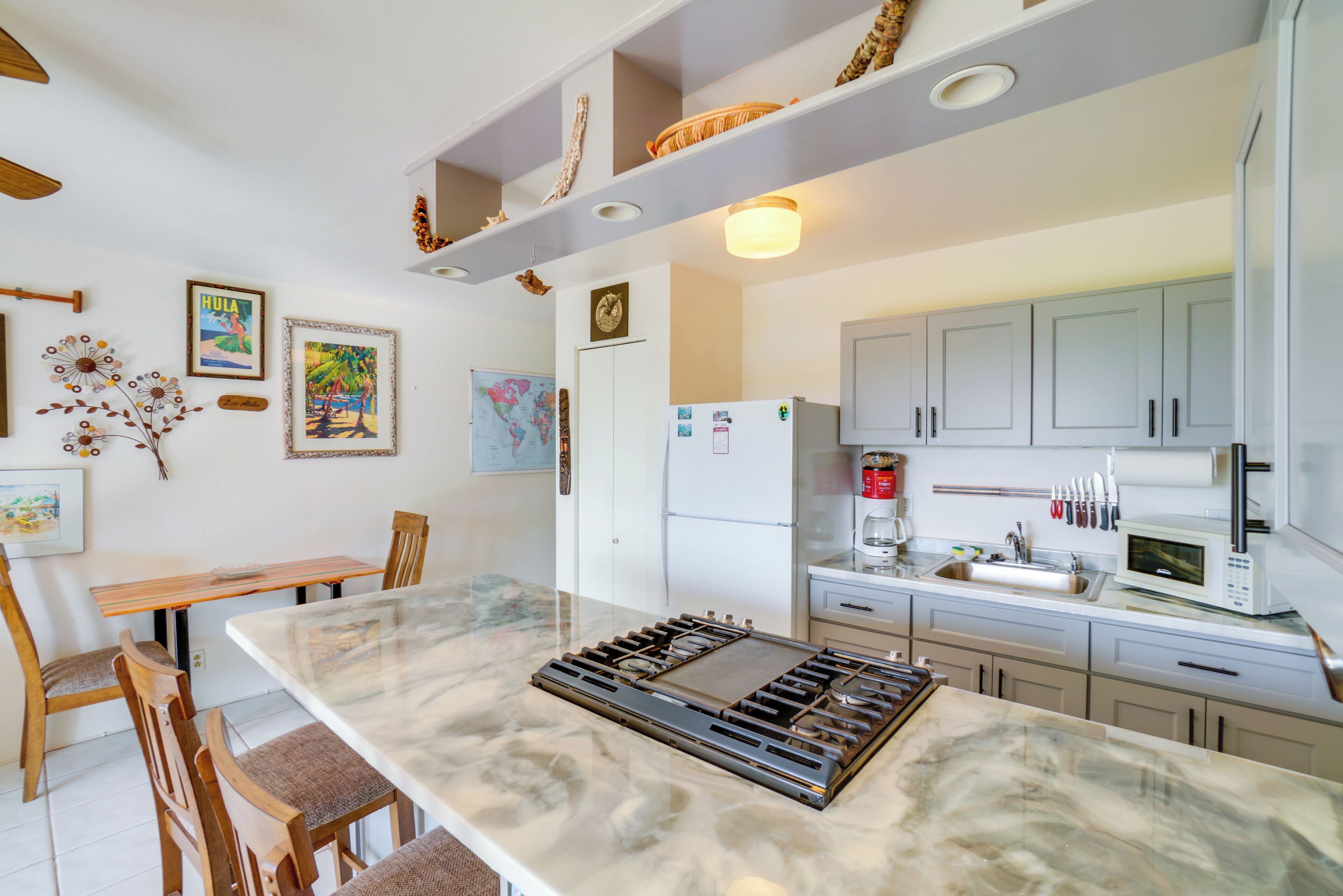 A modern kitchen with a central island, white cabinets, and various kitchen appliances.