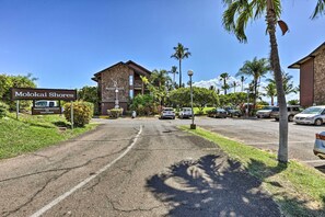 A hotel entrance with a sign reading "Molokai Shores" and a parking lot with several cars. - Pool Access: Ocean-view Molokai Shores Condo! (Kaunakakai)
