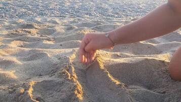 Ein sandiger Strand mit Fußabdrücken und einer Schildkröte.
