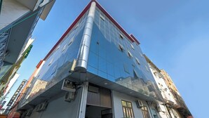 Un bâtiment moderne doté d’une façade en verre réfléchissant, d’un toit rouge et de nombreuses fenêtres.