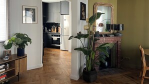 Una cocina moderna con horno y refrigerador integrados, piso de madera y un espejo grande sobre la chimenea.