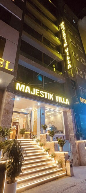 Entrada d'hotel amb un senyal que diu "MAJESTIK VILLA" i una escala que mena a l'entrada.