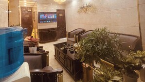 Una sala de estar moderna con un televisor grande, asientos cómodos y plantas decorativas.