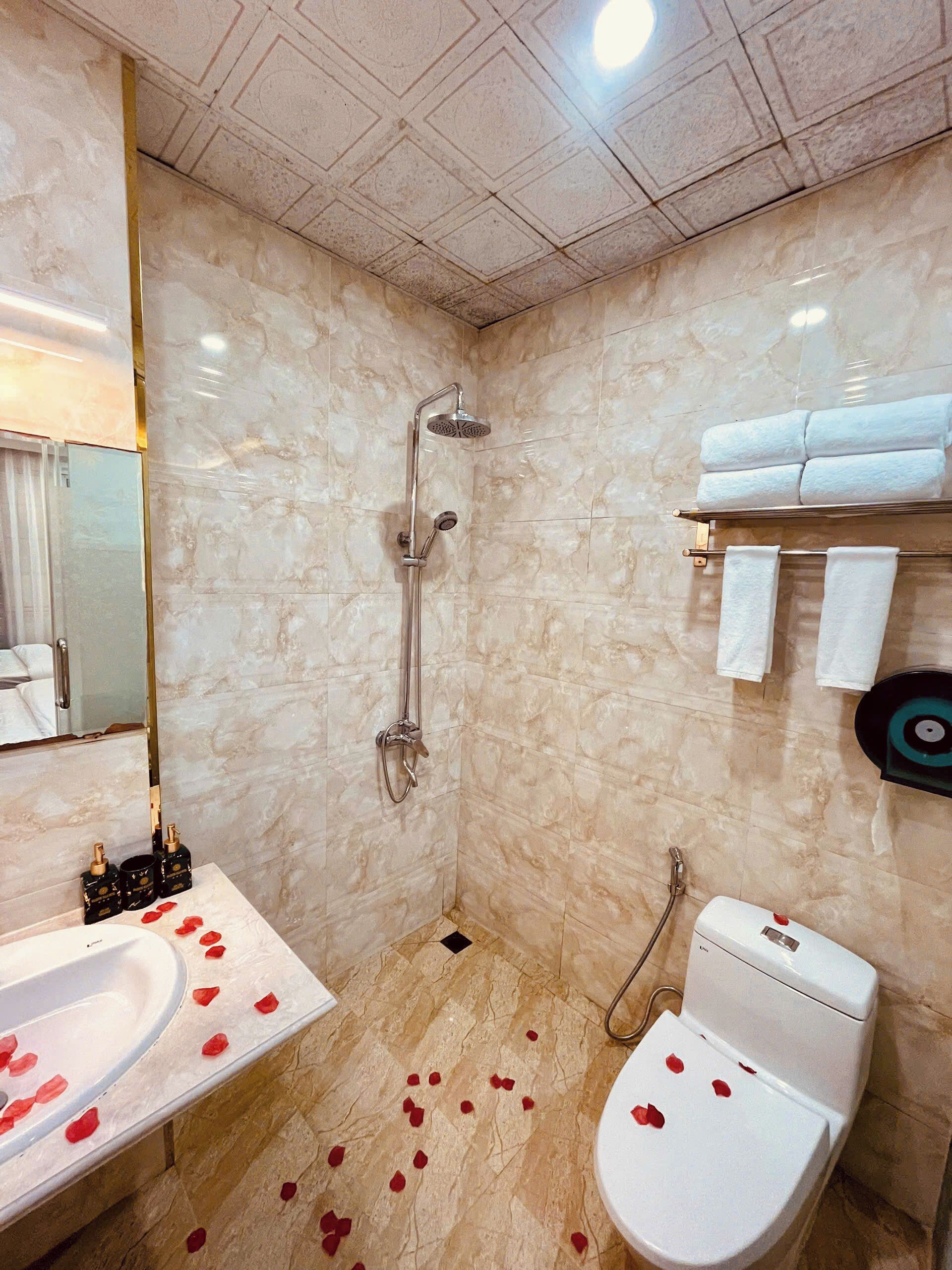 A bathroom with a shower, toilet, and sink.