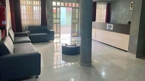 Eine Empfangshalle mit einer Rezeption, zwei Sofas, einem Couchtisch und einer Säule.
