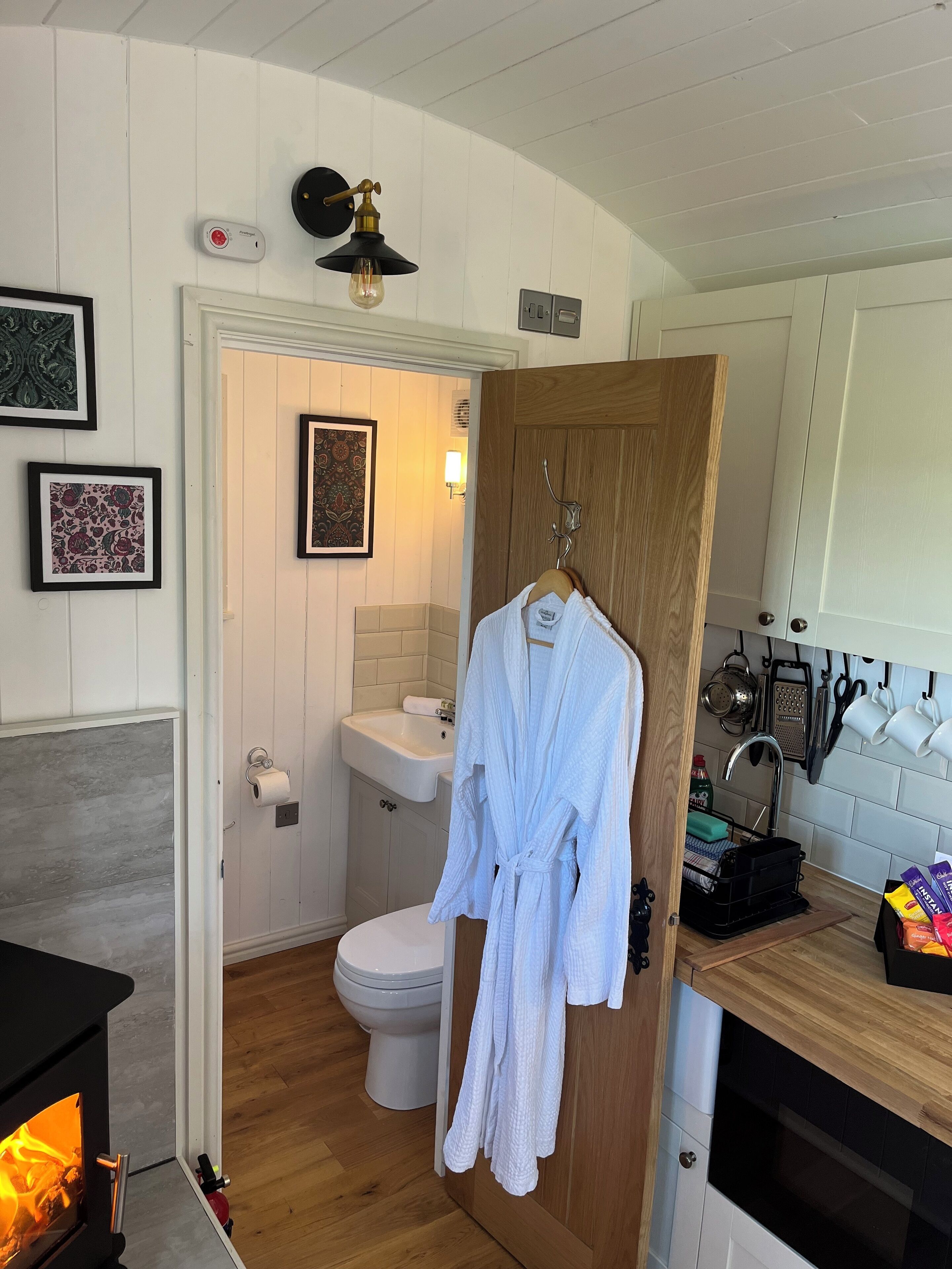 Een badkamer met toilet, wastafel en een kapstok voor handdoeken.