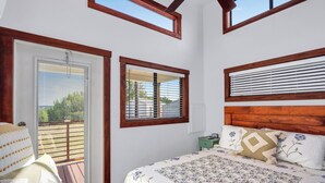 A bedroom with a bed, a window, and a view of the outdoors. - Pet-Friendly Farmhouse Tiny Home w/ Private Deck (Lampasas)
