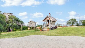 Une ferme rustique avec une petite maison en bois, une grange et une vache qui broute à proximité.