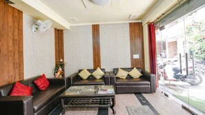 Eine Lobby mit zwei Sofas, einem Couchtisch und einem Wandventilator.