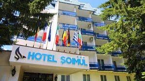 A hotel building with multiple flags, balconies, and a sign reading "HOTEL SOMUL". - Hotel Soimul (Brasov)