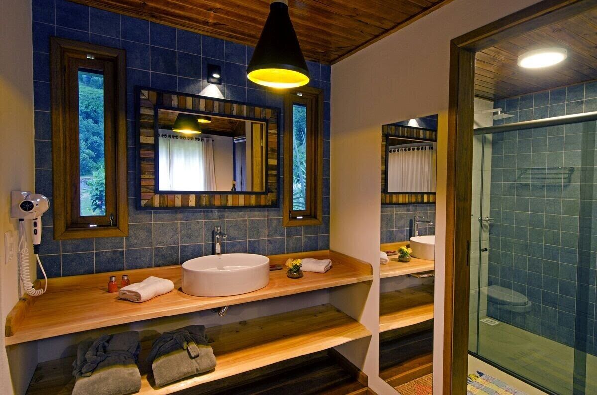 A bathroom with a wooden vanity, a large mirror, and a glass shower enclosure.