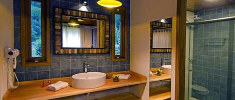A bathroom with a wooden vanity, a large mirror, and a glass shower enclosure.
