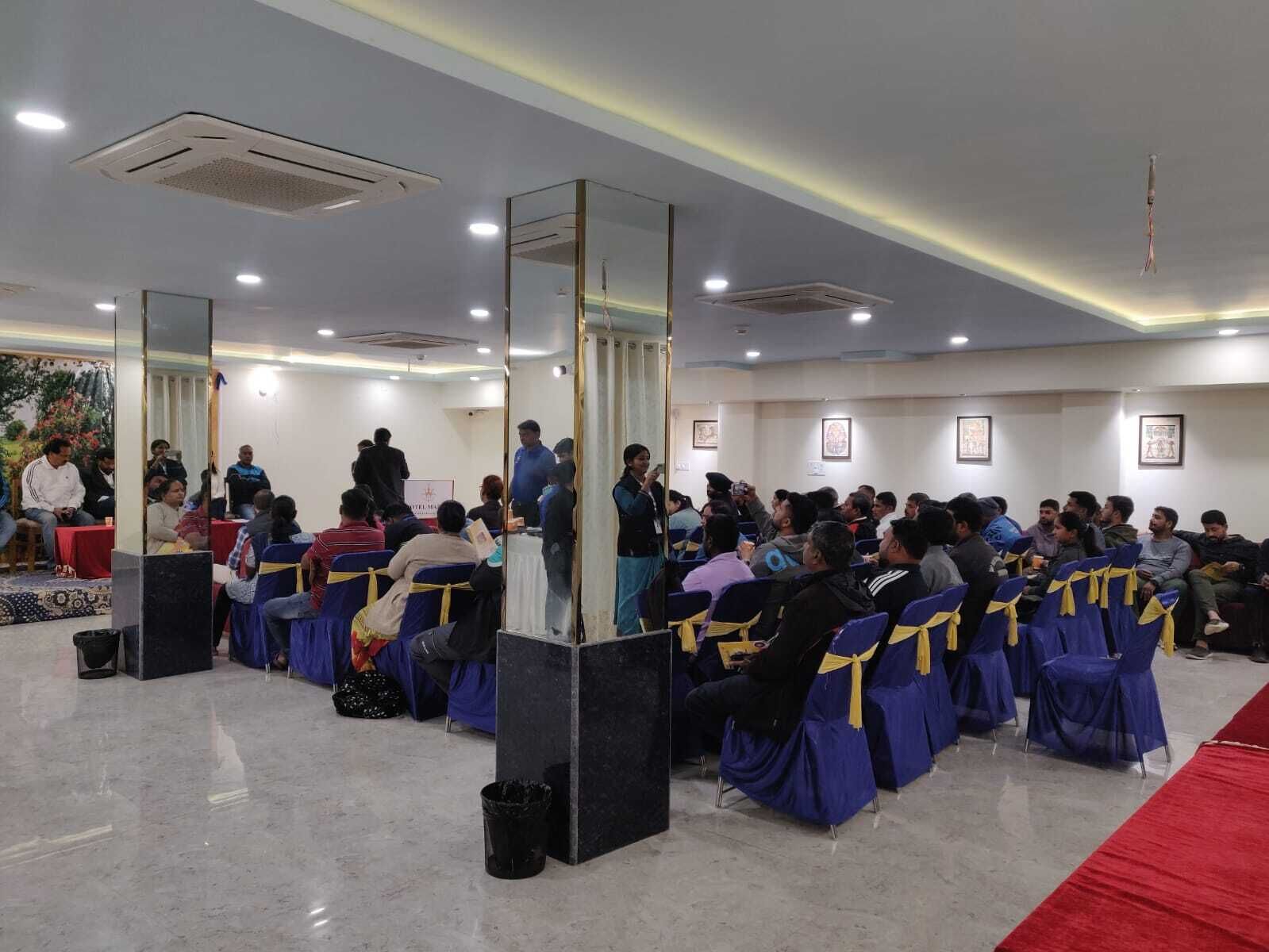 A conference room with rows of chairs, a podium, and a red carpet.