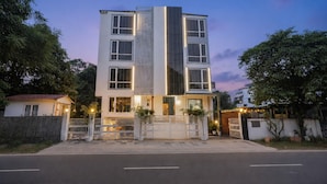 A multi-story building with a modern design, featuring a central vertical glass facade and a gated entrance. - Hotel Marine (Varanasi)