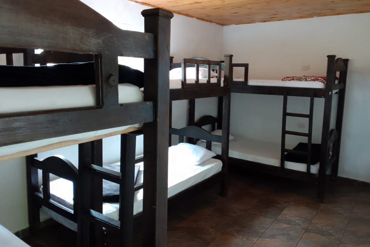 A bunk bed room with wooden bunk beds and a tiled floor.