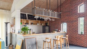 A modern bar area with a concrete counter, wooden stools, and a chalkboard menu. - YOUTEA Holiday Villa (Huzhou)