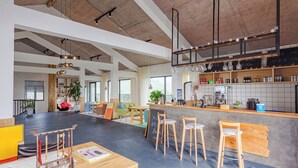 A spacious cafe with high ceilings, exposed beams, and a central bar area. - YOUTEA Holiday Villa (Huzhou)
