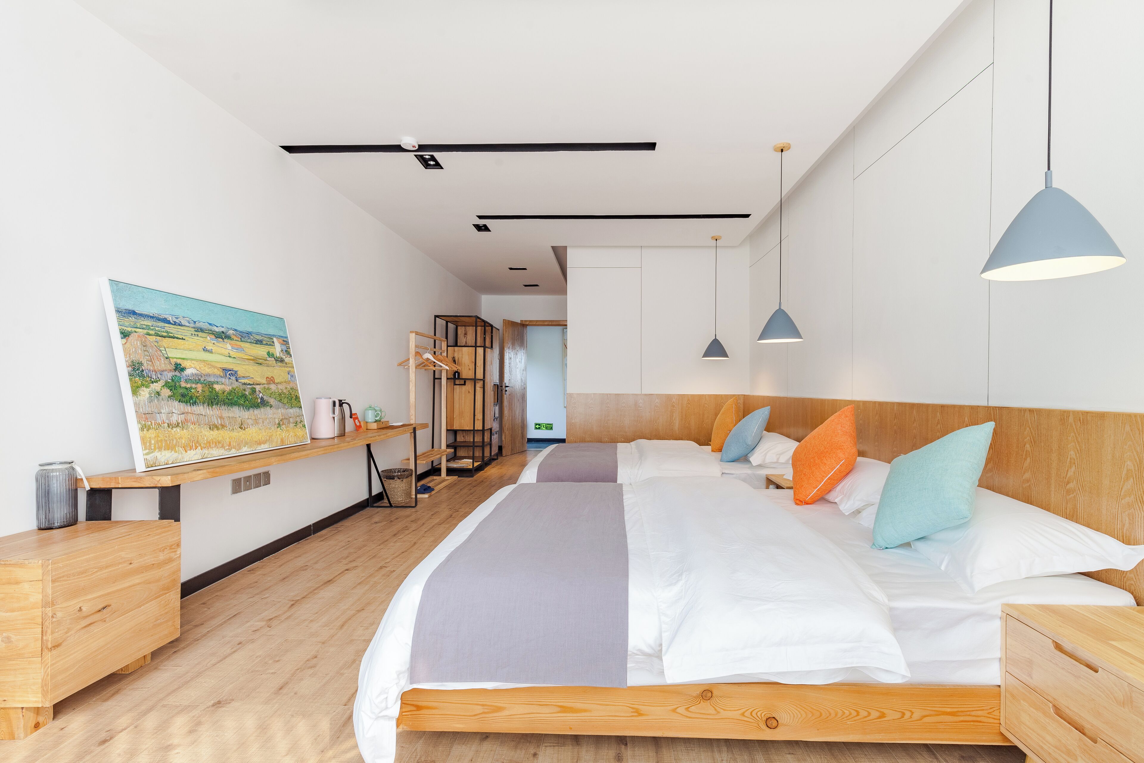 Une chambre à coucher moderne avec un grand lit, une tête de lit en bois et un tableau au mur.