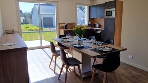Una cocina moderna con comedor, ventanas amplias y vistas al exterior.