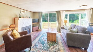 A cozy living room with a fireplace, a television, and a sofa.