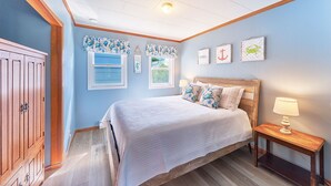 A bedroom with a large bed, wooden headboard, a nightstand, and a wardrobe.