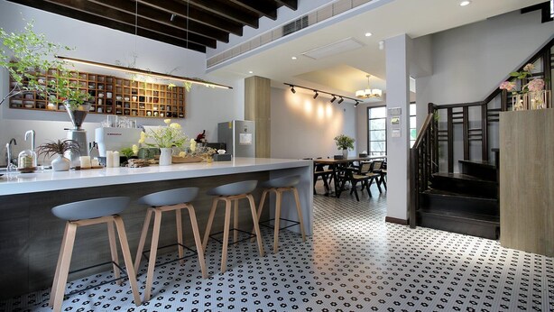 A modern kitchen with a central island, bar stools, and a patterned floor. - Hills boutique (Shanghai)
