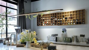 A modern kitchen with a coffee machine, toaster, and a wooden shelf with various kitchen items. - Hills boutique (Shanghai)