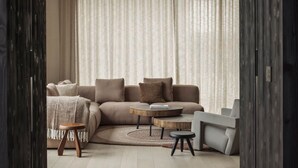 A modern living room with a sectional sofa, two side tables, and a small coffee table. - The Lodge - Luxury Design Villa in Oostduinkerke (Koksijde)