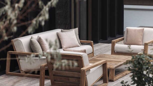 A modern outdoor seating area with a wooden coffee table and two sofas with cushions. - The Lodge - Luxury Design Villa in Oostduinkerke (Koksijde)