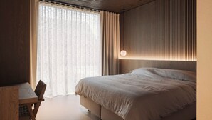 A modern bedroom with a large bed, a desk, and a window with sheer curtains. - The Lodge - Luxury Design Villa in Oostduinkerke (Koksijde)
