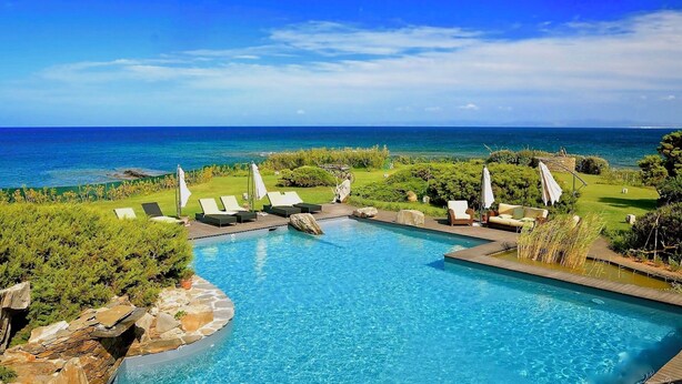 A pool with a view of the ocean, surrounded by lounge chairs and umbrellas. - VILLA DIAMANTE - Seven Bedroom Villa, Sleeps 14 (Stintino)